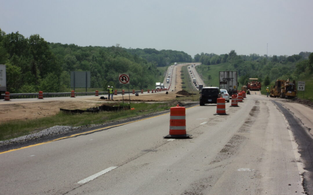 Cars are driving through the work zone on construction highway